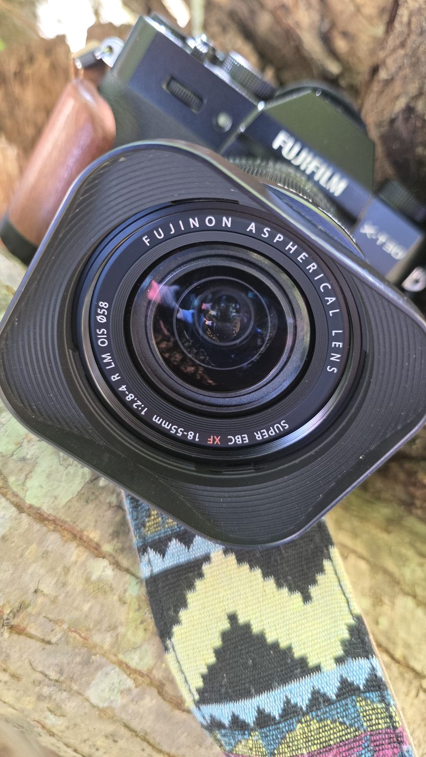 A Fujifilm X-T30 II with a wood grip and square lens hood.