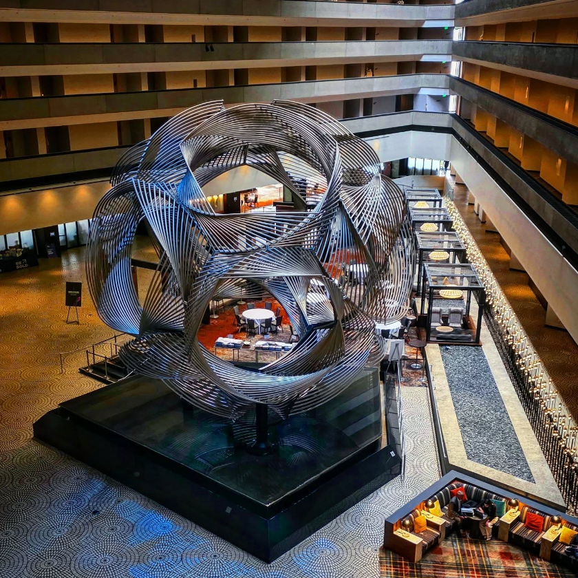 Looking down into the Hyatt Regency San Francisco atrium at Charles O. Perry's Eclipse sculpture, with geometric balconies and lobby levels surrounding it.