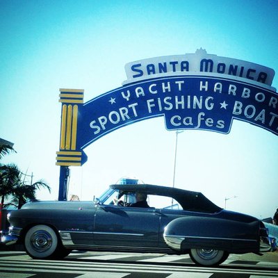 Santa Monica Pier archway sign with vintage convertible at the western terminus of Route 66, California